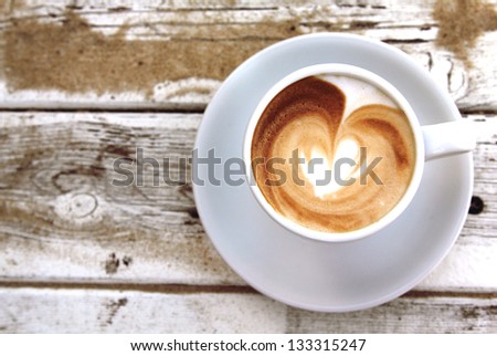 cup of coffee on old wooden table on the beach