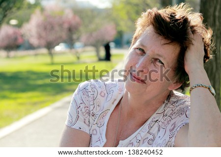 Portrait of 65-years-old beautiful woman outdoors. Beauty and wisdom of age
