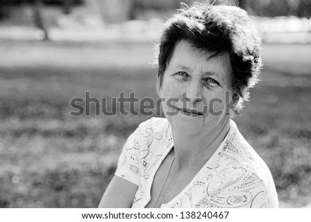 Portrait of 65-years-old beautiful woman outdoors. Beauty and wisdom of age.