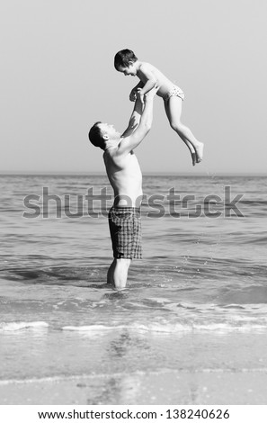 Happy father and son on the beach. black and white photo.