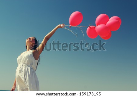 Young Pregnant Woman Holding Red Balloons. Photo In Old Color Image Style.