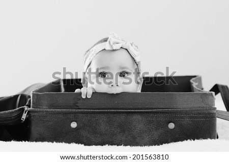 Portrait of aborable baby lying in vintage bag