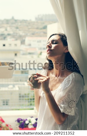 beautiful 35 year old woman stands near the window