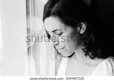 beautiful 35 year old woman stands near the window