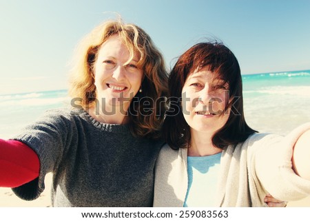 Natural beautiful women smiling on the beach with the sand, sea and blue sky in the background. Selfie