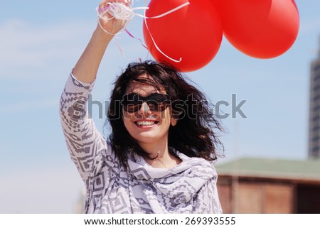 beautiful woman holding red balloons