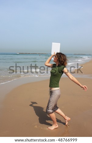 girl wants to throw in the sea her white small laptop