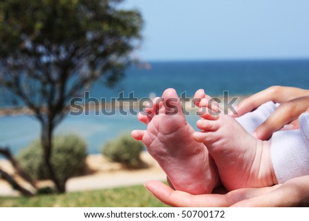 little feet in the mother\'s hands