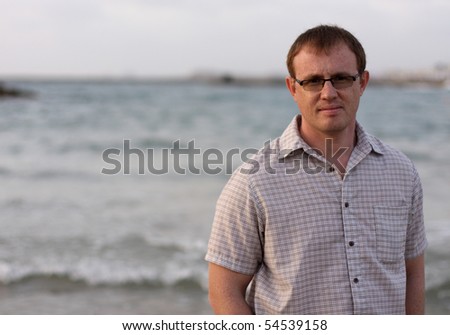 A handsome 35-year-old man in the background of the sea