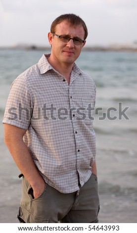 A handsome 35-year-old man in the background of the sea