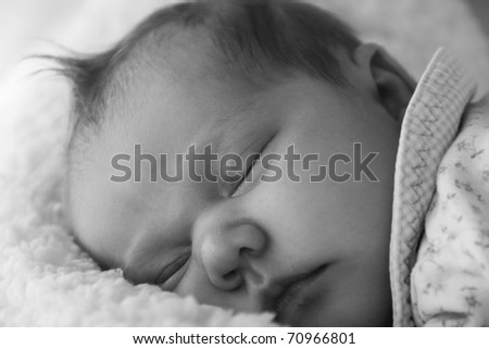 Monthly baby sleeping on a white blanket
