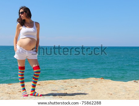 pregnant woman in funny socks at the beach