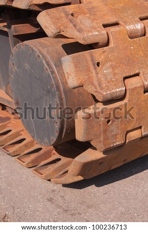 Details of rusted caterpillar tracks of a mobile crane.