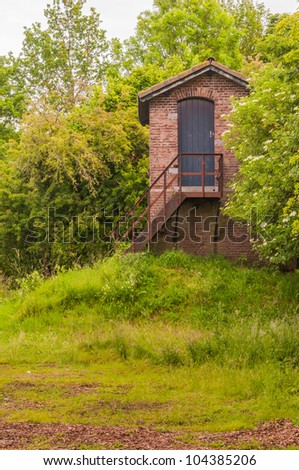 Small hut with a rusty iron stairs and a tiiled roof in the Netherlands.