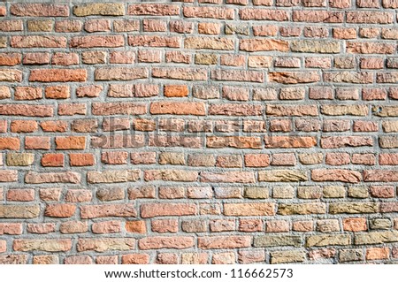Detailed view at a seamless masonry brick wall of orange colored bricks.
