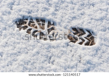 Shoe print in a thin layer freshly fallen snow