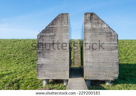 Sawn bunker of reinforced concrete with footpath and a stairs on a dike in the Netherlands.