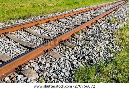 Rusty train tracks on a bed of concrete sleepers and pebbles