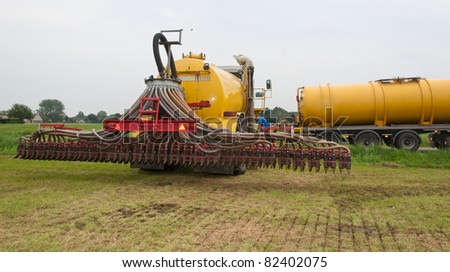 The tank of the manure injector is being filled in the field