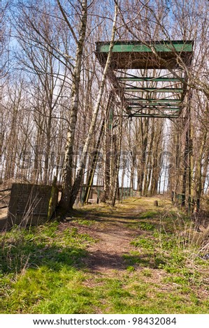 Old and rusty draw bridge in a forest with bare trees.