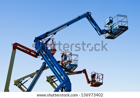Lift buckets in the air against a clear blue sky Lift buckets in the air against a clear blue sky