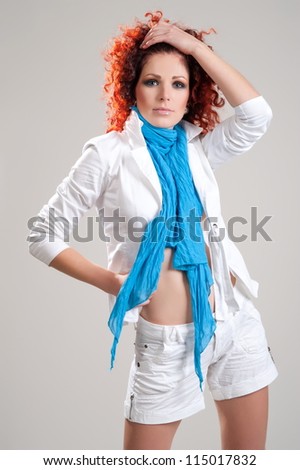 Beautiful girl model with red hair pose on light gray background