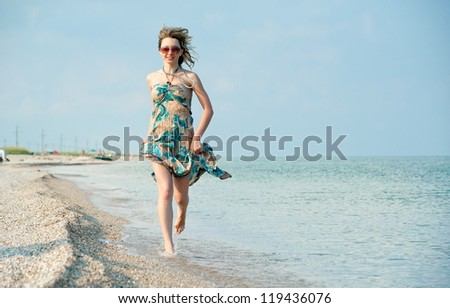 Beautiful sexy blonde girl running on the beach