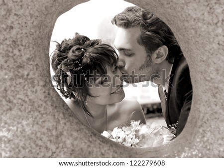 Lucky bridegroom kissing in cheek bride, close-up