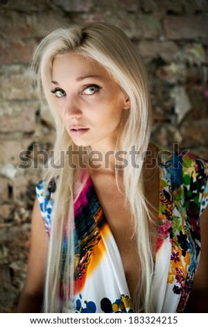 Beautiful sexy blonde girl posing in an old building collapsed
