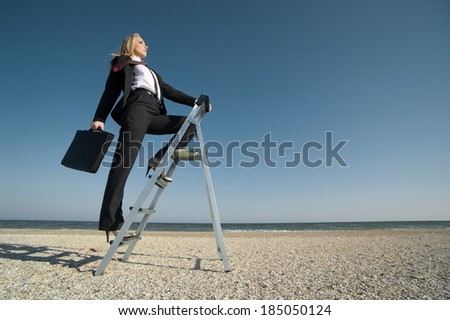 Concept illustrating the desire for new developments, business woman up the stairs standing on the beach