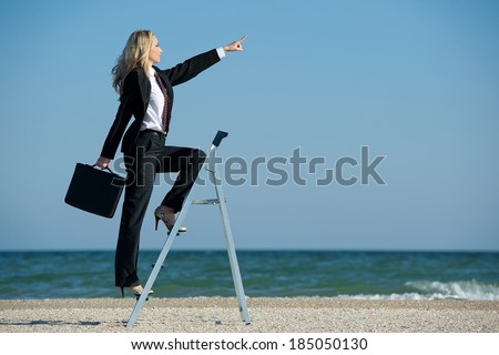 Concept illustrating the desire for new developments, business woman up the stairs standing on the beach