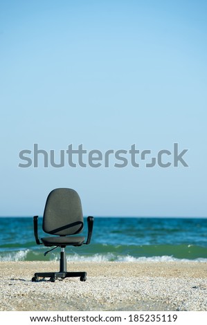 Concept illustrating the opportunity to work remotely, an office chair on the beach