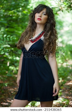 Beautiful sexy brunette girl posing in the summer in the woods