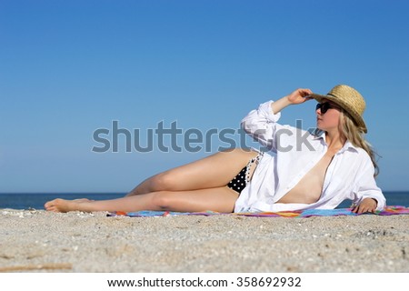 Beautiful girl sexy blonde girl posing on the beach by the sea