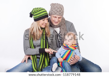Isolated studio shot of happy young family of three wearing winter clothes