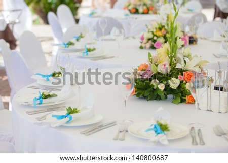 catering table set service with silverware, fresh flowers and glass at restaurant before party