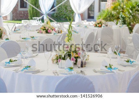 catering table set service with silverware, fresh flowers and glass at restaurant before party