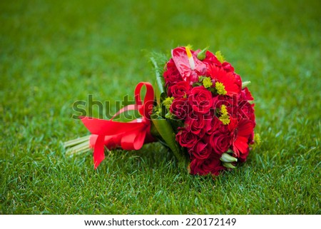 Red wedding bouquet on green field