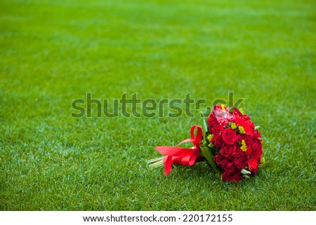 Red wedding bouquet on green field