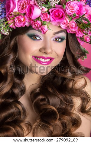 Studio portrait of a beautiful woman with flowers rose in her hair. Flower girl.