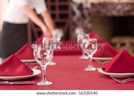 One of waiters is serving dinner place in a restaurant