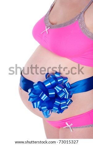 Young and happy beautiful pregnant woman with blue ribbon and bow over her belly