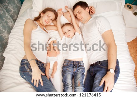 Family lying down in the bedroom