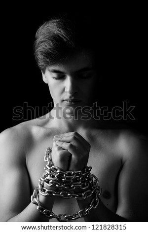 Men locked in metal chain on black background