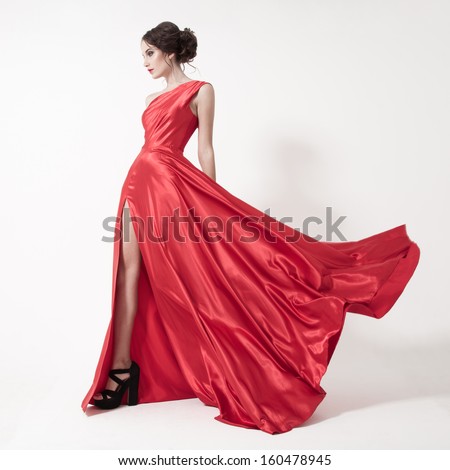 Young Beauty Woman In Fluttering Red Dress. White Background.