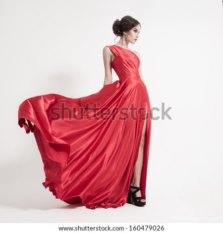 Young Beauty Woman In Fluttering Red Dress. White Background.