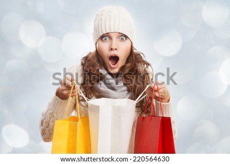 Shopping surprised woman holding bags. Winter sales.