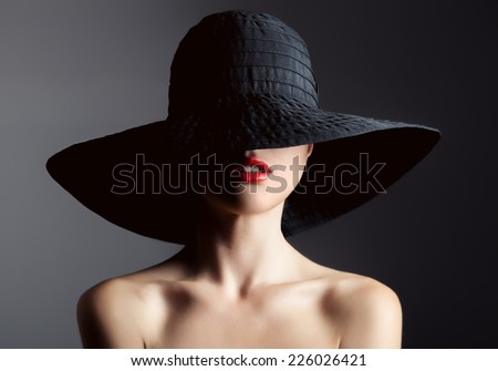 Beautiful woman in hat. Retro fashion. Dark Background.