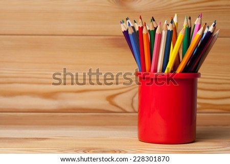Many different colored pencils on wooden table