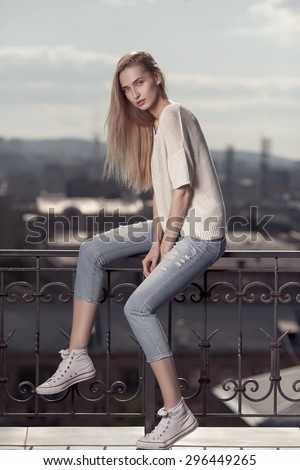 Fashion model. Summer look. Jeans, sneakers, sweater.